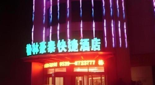 a neon sign on the side of a building at GreenTree Inn Linyi Bus Station in Linyi