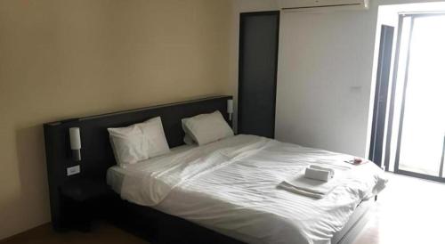 a bed with a black headboard with a book on it at Next Bird Suite in Bangkok