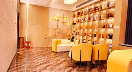a living room with yellow chairs and a table in a room at GreenTree Inn Datong YundinGYAyuan Express Hotel in Datong