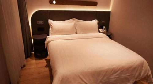a large white bed in a hotel room at GreenTree Inn Datong YundinGYAyuan Express Hotel in Datong
