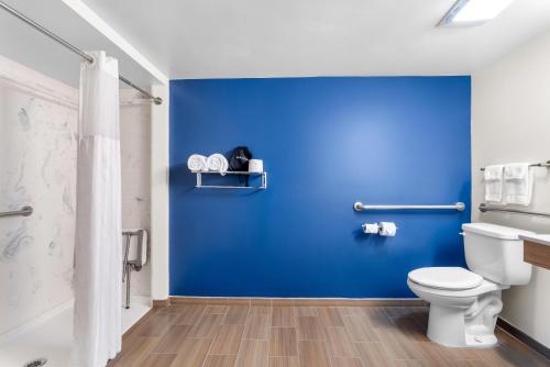 a bathroom with a blue wall and a toilet at Spark by Hilton Kimball in Kimball