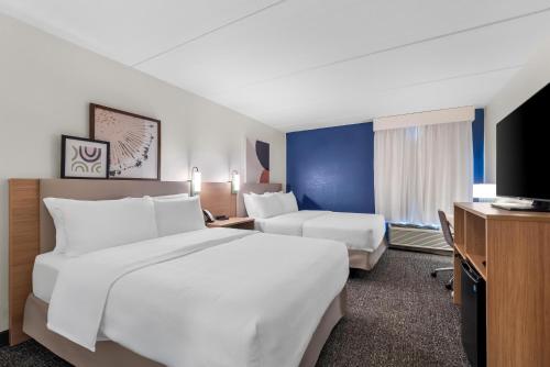 a hotel room with two beds and a flat screen tv at Spark by Hilton Kimball in Kimball