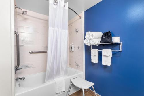 a bathroom with a tub and a shower with a blue wall at Spark by Hilton Kimball in Kimball