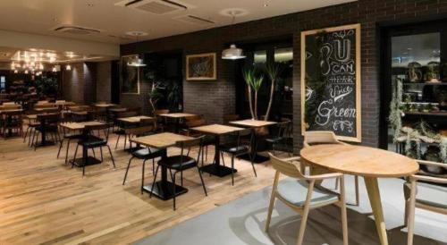 a restaurant with wooden tables and chairs in a room at Hotel Edit Yokohama in Yokohama