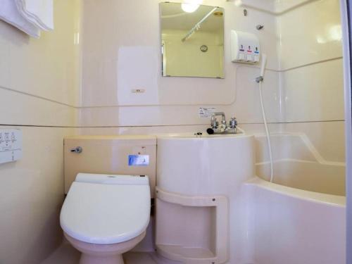 a bathroom with a toilet and a sink and a tub at Tabist Hotel New Osamura Sabae in Fukui
