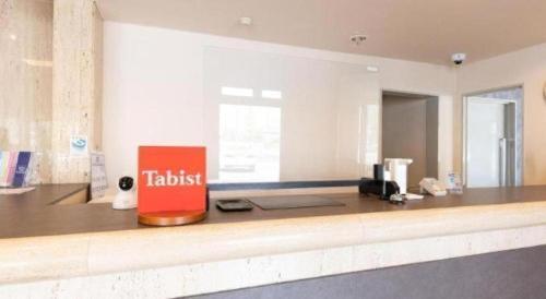 a kitchen with a counter with a red sign on it at Tabist Hotel New Osamura Sabae in Fukui