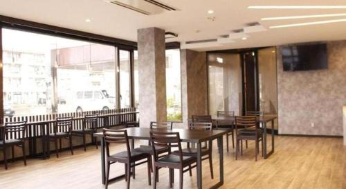 a dining room with tables and chairs in a building at Tabist Hotel New Osamura Sabae in Fukui