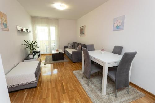 un soggiorno con tavolo, sedie e divano di Apartman Central Bliss Mostar a Mostar