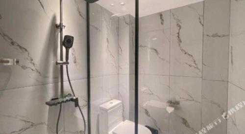 a white bathroom with a shower and a toilet at 7 Days Inn Deyang Zhongjiang Kuishan Park in Deyang