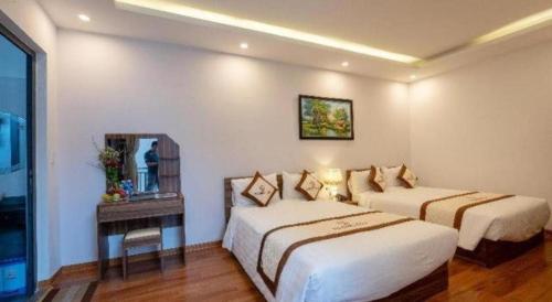 a hotel room with two beds and a mirror at Hoi An Paradise Villa in Hoi An