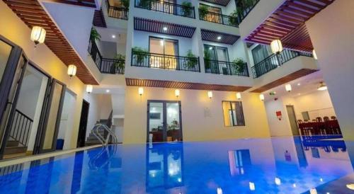 a large swimming pool in a building with a building at Hoi An Paradise Villa in Hoi An