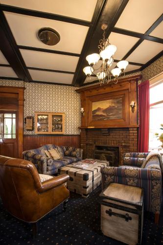 a living room with couches and a fireplace at Okoroire Hot Springs Hotel in Okoroire