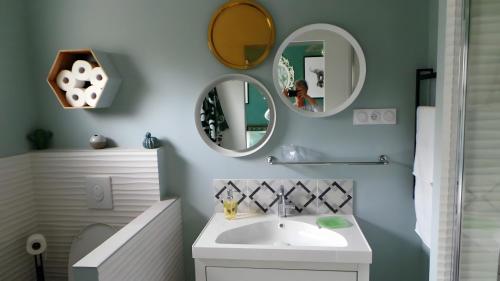 a bathroom with a sink and mirrors on the wall at Les Arbousiers in Boulouris-sur-Mer