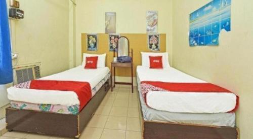 a bedroom with two beds with red and white sheets at SPOT ON 90625 Super Green Grass Hotel in Yong Peng