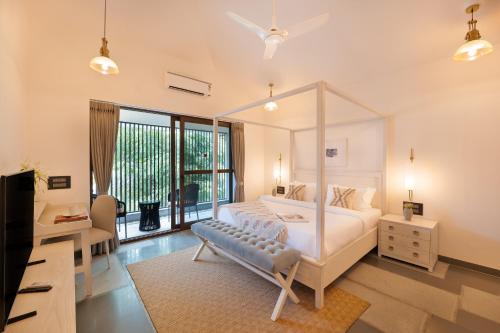 アンジュナにあるMelhor stays villas - L-S08 4BHK villa with private poolのベッドルーム(天蓋付きベッド1台、テレビ付)