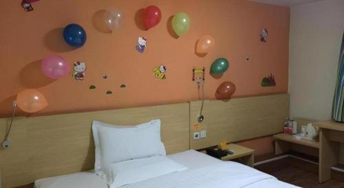 a bedroom with balloons on the wall and a bed at 7 Days Inn West Gate of Taiyuan University of Technology in Taiyuan