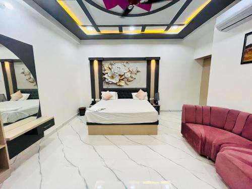 a bedroom with a bed and a couch at The Glitch Hotel And Restaurant in Jaswantnagar