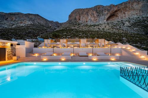 a villa with a swimming pool at night at Analeia Luxury Hotel - Adults Only in Kalymnos