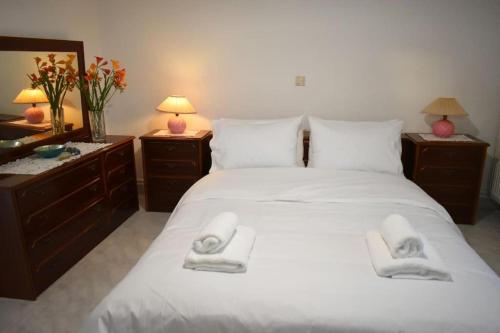 a bedroom with a large white bed with towels on it at Avli Guesthouse 
