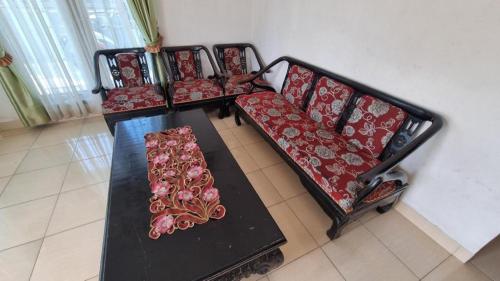 a row of chairs with red cushions on a table at Hotel O Wisma Sidosari Syariah in Bandar Lampung