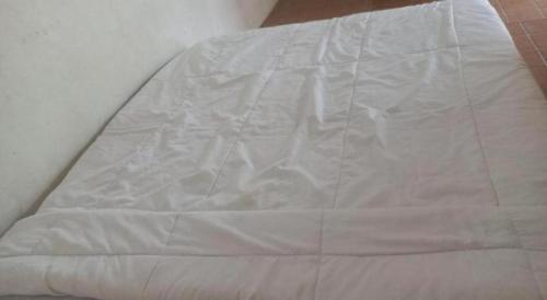 a close up of a white bedsheet on a bed at Hotel O Endj Walet Samodra in Tepus