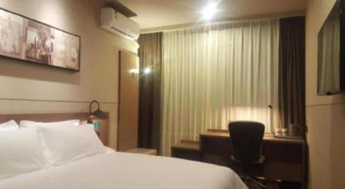 a hotel room with a bed and a window at Jinjiang Inn Select Shanghai Fengxian Baolong Square North Yunhe Road in Shanghai