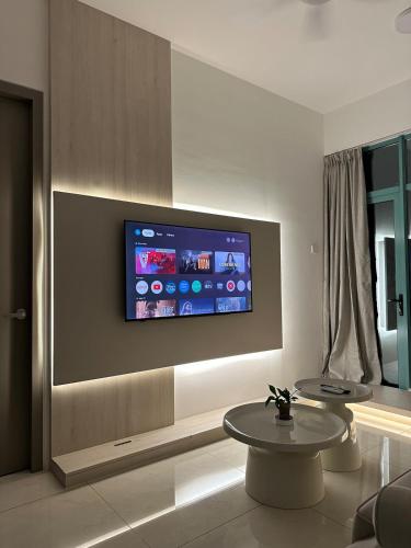 a living room with two tables and a tv on the wall at Deluxe 2BR Seaview and Mountain View with balcony in Kota Kinabalu