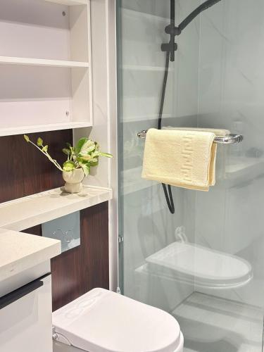 a bathroom with a toilet and a glass shower at Deluxe 2BR Seaview and Mountain View with balcony in Kota Kinabalu