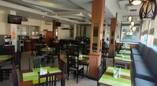 a restaurant with tables and chairs in a restaurant at Jelita Tanjung Hotel in Tanjung