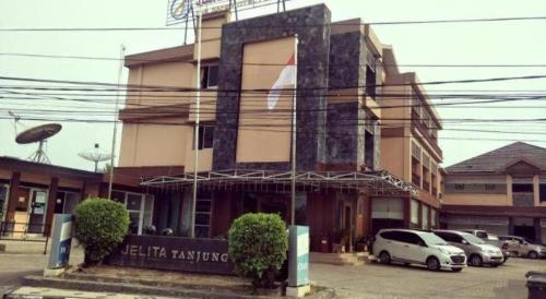 a building with cars parked in front of it at Jelita Tanjung Hotel in Tanjung