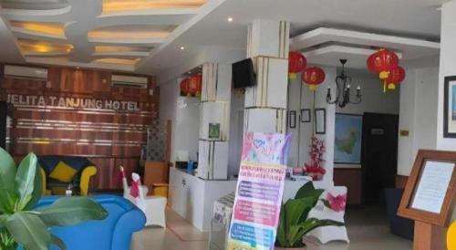 a living room with a blue couch in a room at Jelita Tanjung Hotel in Tanjung