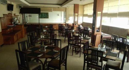 a dining room with tables and chairs in a restaurant at Jelita Tanjung Hotel in Tanjung