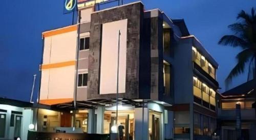a building with a clock on the front of it at Jelita Tanjung Hotel in Tanjung