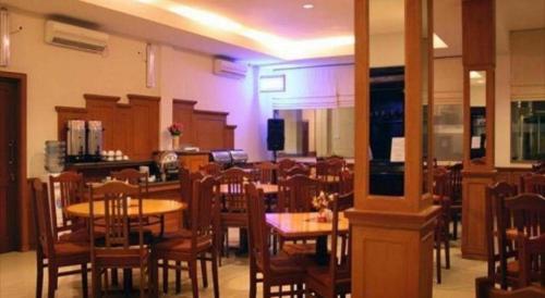 a dining room with tables and chairs in a restaurant at Jelita Tanjung Hotel in Tanjung