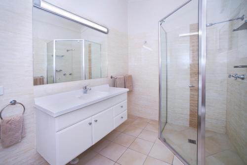 uma casa de banho branca com um lavatório e um chuveiro em Boulevarde Motor Inn em Wagga Wagga