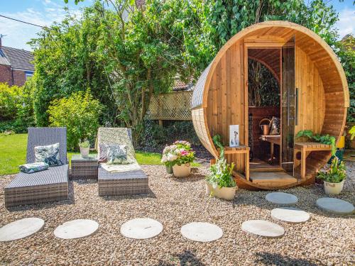 a garden with two chairs and a hobbit house at The Manse in Coxhoe