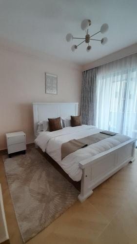 Un dormitorio con una gran cama blanca y una ventana. en Cedar Crest, en Nairobi