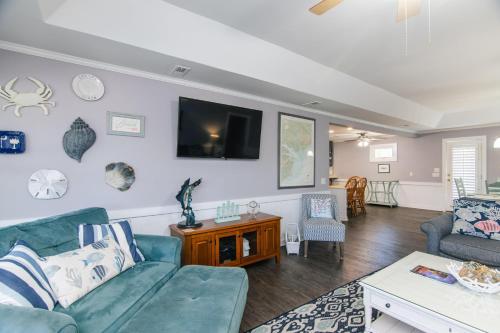 a living room with a couch and a tv on the wall at Sutton House in Edisto Island