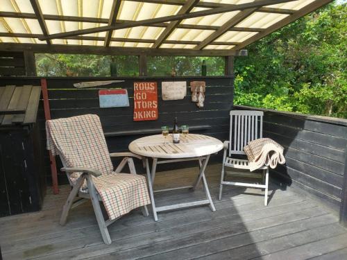 a patio with a table and two chairs on a deck at Kathøje in Lemvig