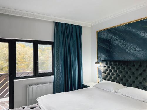 a bedroom with a bed and a large window at Suru Hotel & Restaurant in Buşteni