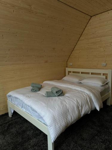 1 cama en una habitación de madera con 2 toallas en High mountain Apartment, en Vyshka
