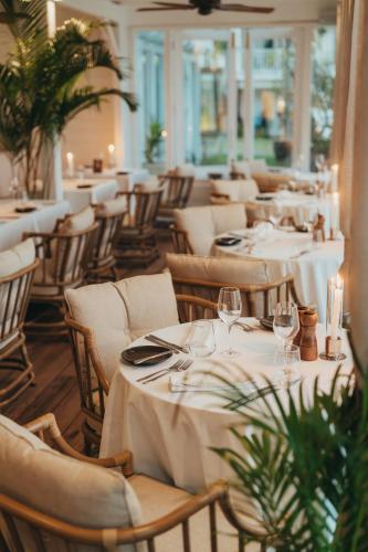 a restaurant with white tables and chairs with glasses at La Maison 20 Degrés Sud - Relais & Châteaux in Grand Baie