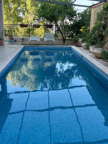 a swimming pool with blue water in a yard at פינת נופש- סויטת הרימון עם בריכה פרטית - 6 אורחים in Rosh Pinna