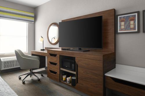 a room with a television on a desk with a chair at Hampton Inn St. George in St. George
