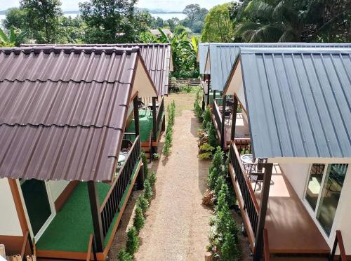 a pathway between two buildings with tables and plants at The white resort & restaurant koh yao yai in Ban Khlong Hia