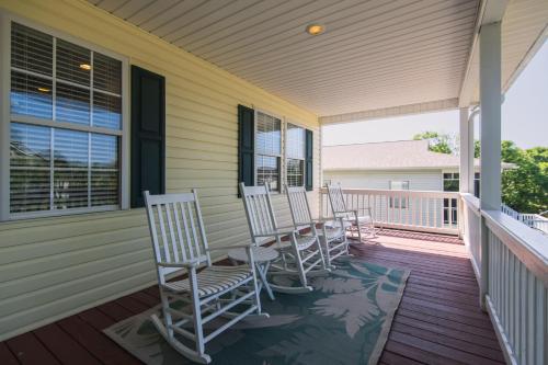 a row of rocking chairs sitting on a porch at Suite Caroline in Edisto Island