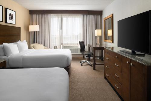 a hotel room with two beds and a flat screen tv at DoubleTree by Hilton Hotel Boston Bayside in Boston