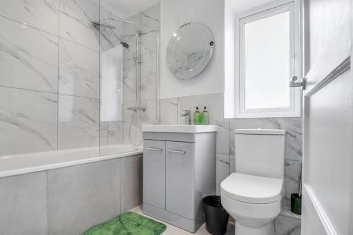 a white bathroom with a toilet and a shower at Modern 3Bed Escape - Work&Relax - Free Parking in Chigwell