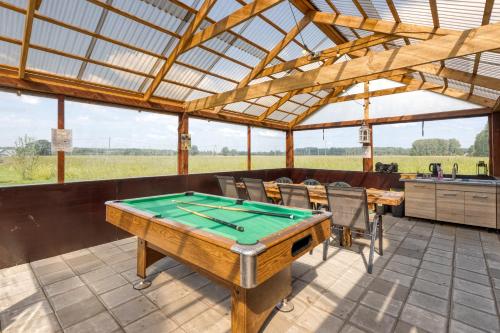 a ping pong table in a pavilion with a table at Pirts māja Ramatas in Skulte