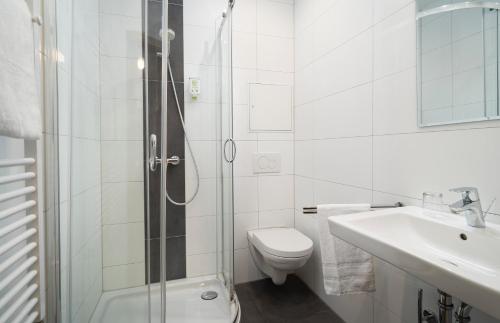 a bathroom with a toilet and a sink and a shower at ates Hotel Lampertheim by AURUM in Lampertheim